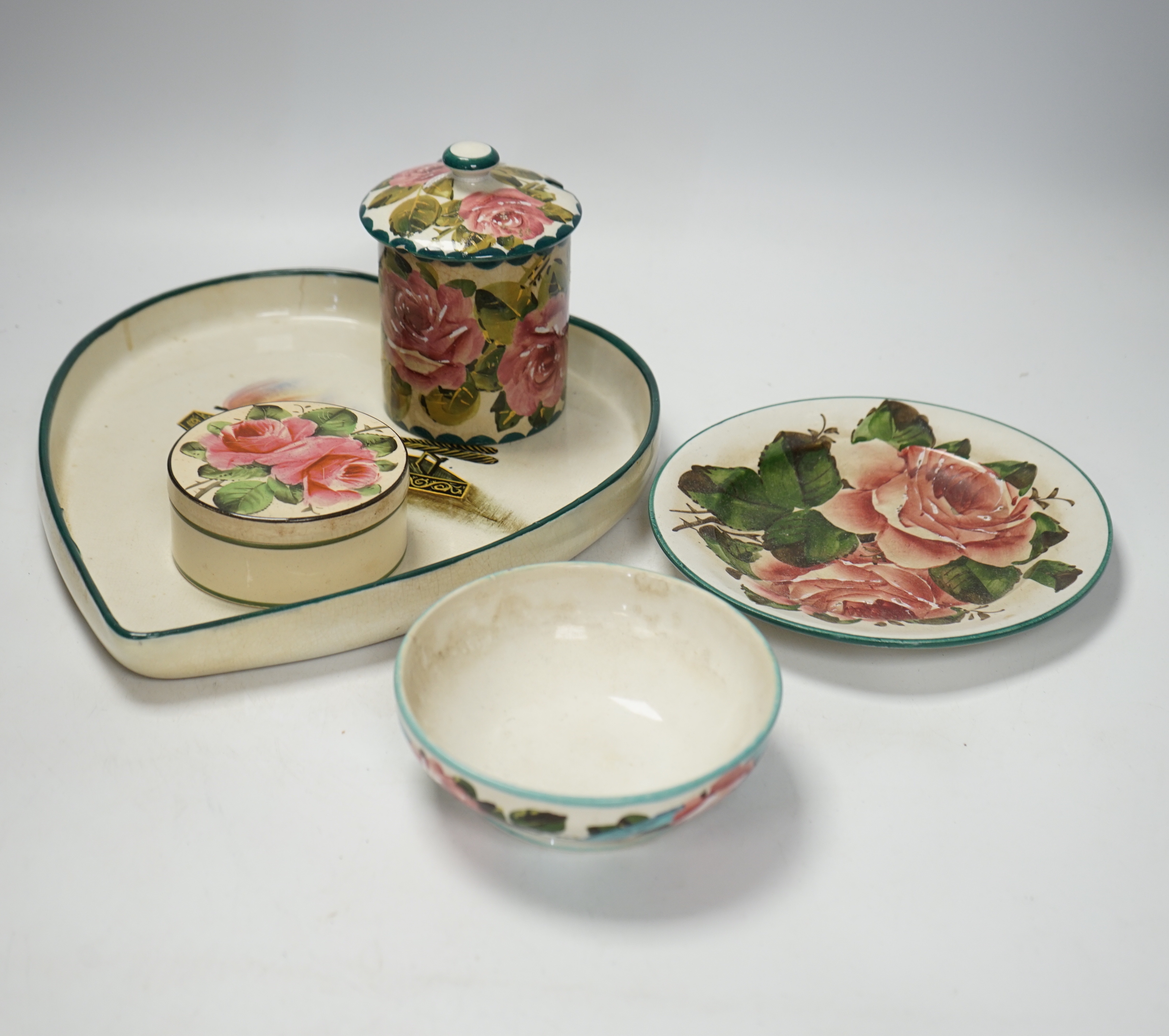 Wemyss ware - a roses preserve jar, three other items and an unusual ‘hair tongs’ heart shaped dish, largest 30cm